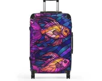 May include: A rolling suitcase featuring a stained-glass design with two goldfish. The fish are orange, pink, and yellow, set against a blue and purple background. The suitcase has a retractable handle and black wheels.