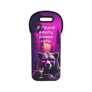 Puede incluir: Funda para botella de vino con un diseño morado y negro. La funda presenta un oso con gafas de sol sosteniendo una copa de vino. El texto "IF FOUND empty please refill" está impreso en la funda.