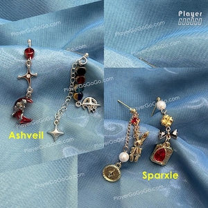 Pu&ograve; includere: Sono mostrati due paia di orecchini pendenti. Un paio, etichettato "Ashveil", presenta un ciondolo a forma di luna crescente rossa e una croce. L'altro paio, etichettato "Sparxie", include una gemma rossa e un ciondolo a forma di moneta d'oro. Entrambi i paia hanno design unici.