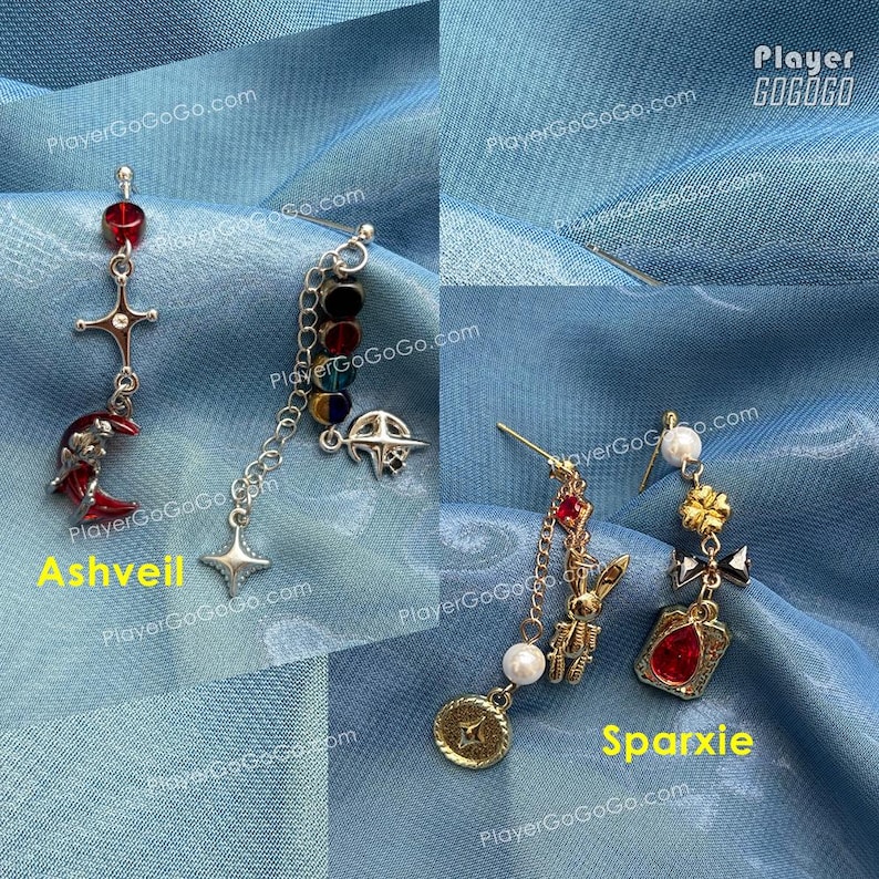 Pu&ograve; includere: Sono mostrati due paia di orecchini pendenti. Un paio, etichettato "Ashveil", presenta un ciondolo a forma di luna crescente rossa e una croce. L'altro paio, etichettato "Sparxie", include una gemma rossa e un ciondolo a forma di moneta d'oro. Entrambi i paia hanno design unici.