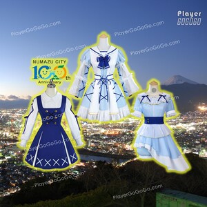May include: Three anime-style dresses on mannequins. The dresses are in shades of blue and white, with decorative bows and trim. One dress has a dark blue bodice and white sleeves. The image includes the text "NUMAZU CITY 10th Anniversary".