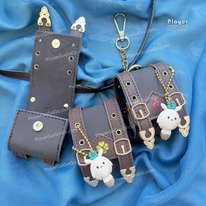 May include: A collection of brown leather accessories, including a pouch, a belt, and two small cases with buckles. Each case features a gold-colored charm with a white bunny figure. The text "PlayerGoGoGo.com" is visible.