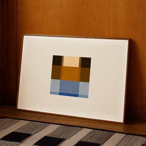 以下が含まれることがあります： 茶色、タン、青、黒の正方形で構成された幾何学模様の、額装された抽象芸術プリント。 アートワークは木の床に置かれ、木の壁に立てかけられています。 ストライプのラグが手前にあります。