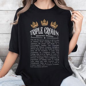 May include: Black t-shirt with a gold crown design and the text "TRIPLE CROWN Memory Master." The shirt lists various memory work topics, including history, science, and grammar. A stylish and educational apparel item.