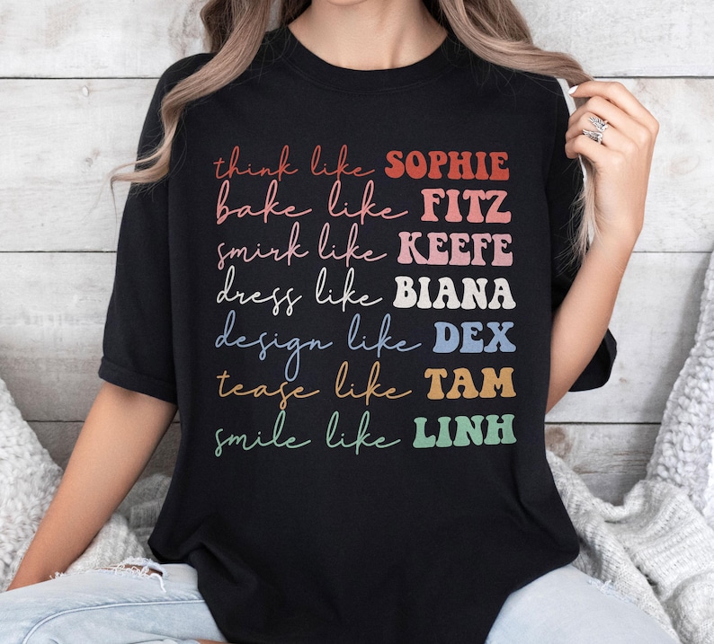 Puede incluir: Camiseta negra con texto colorido que dice "think like SOPHIE, bake like FITZ, smirk like KEEFE, dress like BIANA, design like DEX, tease like TAM, smile like LINH". El texto est&aacute; en varios colores y fuentes.