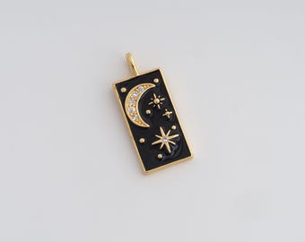 May include: Gold-tone pendant with a black enamel background featuring a crescent moon embellished with clear crystals and several star designs. The rectangular pendant has a gold border and a loop for a chain.