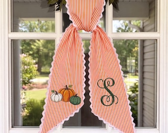 Gepersonaliseerde herfstkranssjerp – Geborduurde pompoenen en een gepersonaliseerd monogram op oranje gestreepte stof met geschulpte kant.