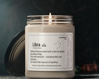 May include: A lit candle in a glass jar with a black lid. The label reads "Libra" with a description and constellation graphic. The candle is scented with coconut cream and cardamom.