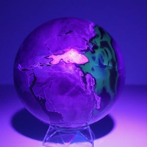 Esfera grande de ágata volcánica reactiva a los rayos UV: ¡presenta una formación de calcita con forma de tiburón!
