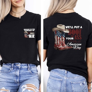 May include: Black t-shirt with a patriotic design. The front features text and a graphic of red, white, and blue cowboy boots. The back of the shirt displays a cowboy boot design with the text "We'll put a boot in your ass the American way."