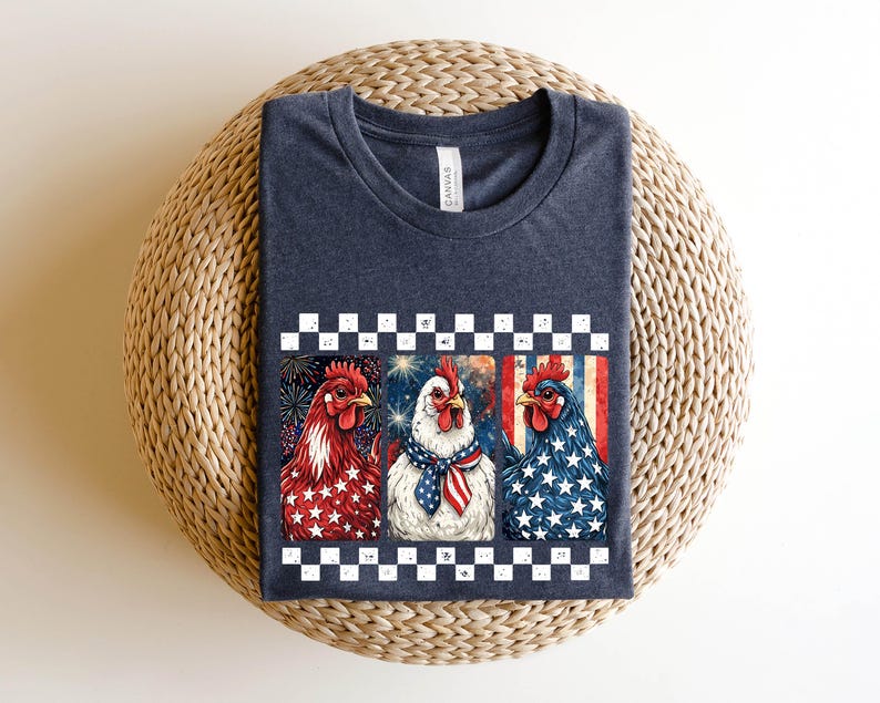 May include: A navy blue t-shirt featuring a graphic of three chickens with patriotic designs. The chickens are decorated with red, white, and blue stars and stripes, and are set against a checkered border.