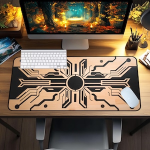 May include: A computer desk setup with a wooden desk mat featuring a black and tan circuit board design. A white keyboard and mouse are on the mat. The computer monitor displays a forest scene. Other items include a pen holder and books.