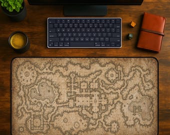 May include: A detailed, beige and brown map-themed desk mat with a black border. The mat features a fantasy map design, with a keyboard, monitor, coffee cup, and other items on a wooden desk. A small plant and a leather-bound notebook are also visible.