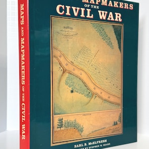 Könnte beinhalten: Ein Hardcover-Buch mit dem Titel "MAPS AND MAPMAKERS OF THE CIVIL WAR". Das Cover ist teal mit einer detaillierten Kartenillustration in der Mitte. Der Buchrücken ist rot mit dem Titel vertikal gedruckt. Autor: Earl B. McElfresh.