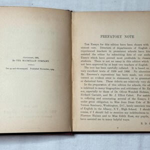 May include: An open book with aged, off-white pages. The left page has text indicating copyright by The Macmillan Company in 1905. The right page features a prefatory note discussing the essays within the book.