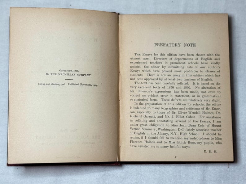 May include: An open book with aged, off-white pages. The left page has text indicating copyright by The Macmillan Company in 1905. The right page features a prefatory note discussing the essays within the book.
