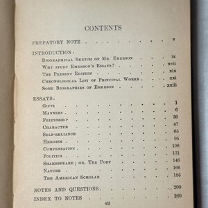 May include: An open book showing a contents page with a list of essays. The paper has a tan colour, with titles such as "Gifts", "Manners", and "The American Scholar" listed. The book is open to page vii.