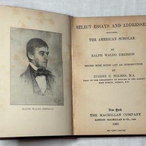 May include: An open book titled "Select Essays and Addresses" by Ralph Waldo Emerson. The left page displays a portrait of Emerson. Published in 1905 by The Macmillan Company, New York.
