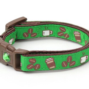 Peut inclure: Collier pour chat vert et marron avec un motif de tasse à café et de grains de café. Le collier est doté d'une petite cloche verte.
