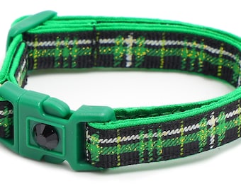 May include: Green and black plaid cat collar with a black bell and a green plastic buckle.