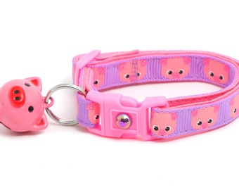 May include: Pink cat collar with a pig design and a pink bell. The collar has a plastic buckle and a silver ring.
