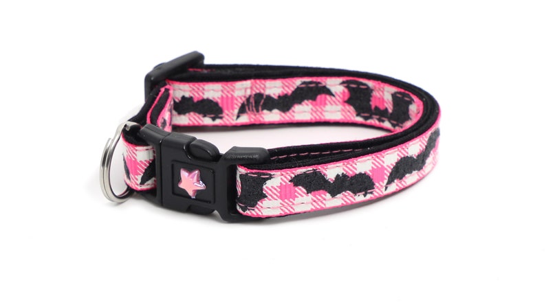 Puede incluir: Collar de perro de cuadros rosa y blanco con murci&eacute;lagos negros y un dije de estrella rosa.