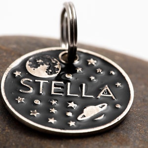 Pet name tag shown at an angle to illustrate the thick and durable metal from which it is made.