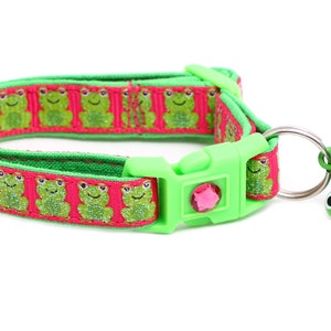 Puede incluir: Un collar para gato verde y rosa con estampado de rana y una campanita de rana verde. El collar tiene una hebilla de plástico y un cierre de seguridad.