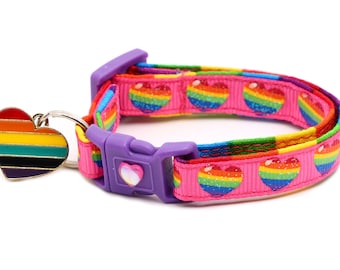 Può includere: Un collare per animali domestici rosa con un motivo a forma di cuore arcobaleno e un ciondolo a forma di cuore arcobaleno. Il collare ha una fibbia in plastica viola.