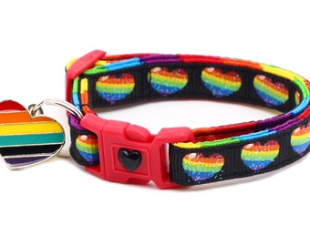 Può includere: Un collare per gatti nero con cuori arcobaleno e un ciondolo a forma di cuore arcobaleno. Il collare ha una fibbia in plastica rossa.