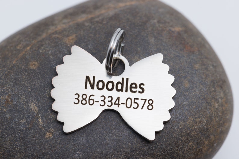 Back side of the pet tag showing an example name and phone number. The font is Calibri.