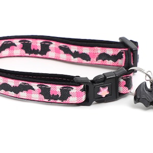 Puede incluir: Collar de gato rosa y negro con un dije de murci&eacute;lago negro. El collar tiene una hebilla negra y una estrella rosa en la hebilla. El collar est&aacute; hecho de un material suave y c&oacute;modo.