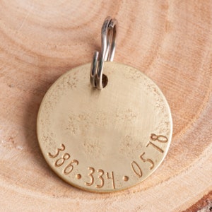 Back of the tag showing one example photo number. The number is stamped along the round edge and is centered.