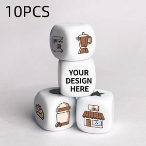May include: White dice with coffee-themed illustrations and the text "YOUR DESIGN HERE". The dice feature images of a coffee maker, a coffee pot, a coffee shop, a coffee cup, and a pastry. The number "10PCS" is in the top left corner.