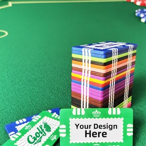 May include: A stack of colorful poker chips with a green felt background. The chips are in various colors, including blue, green, red, and brown. One green chip has the text "Golf Club" and another has the text "Your Design Here".