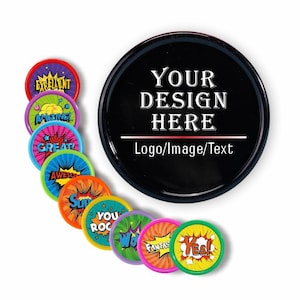 May include: A black round button with the text "YOUR DESIGN HERE" and several colorful round buttons with words like "EXCELLENT" and "AMAZING!" in a comic book style. The buttons are on a white background.