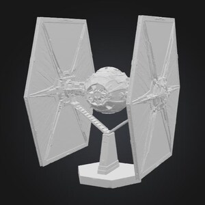 K&ouml;nnte beinhalten: Ein hellgraues TIE-Fighter-Modell, ein Raumschiff aus einem Science-Fiction-Franchise. Das Modell verf&uuml;gt &uuml;ber ein zentrales kugelf&ouml;rmiges Cockpit und zwei gro&szlig;e, sechseckige Sonnenkollektoren auf beiden Seiten. Es ist auf einem rechteckigen Sockel montiert.