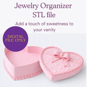 Könnte beinhalten: Ein rosa herzförmiger Schmuckorganizer mit passendem Deckel, verziert mit einer Schleife und kleinen weißen Herzen. Der Text lautet "Fake Cake Heart Jewelry Organizer STL file" und "Add a touch of sweetness to your vanity."