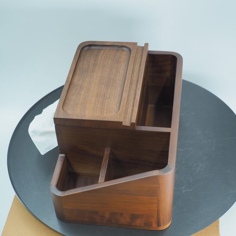May include: A wooden desk organizer with a rich, dark brown finish. The organizer features multiple compartments, including a tray on top and several open sections for storage. The design is modern and minimalist, suitable for office or home use.