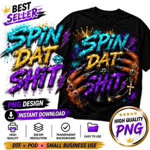 May include: A black t-shirt featuring a graphic design with the text SPIN DAT SHIT in dripping blue, gold, and purple letters. The design includes a crown, a diamond, and hands with long nails adorned with rings and a cross pendant necklace.