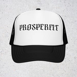Puede incluir: Gorra de camionero en blanco y negro con la palabra "PROSPERFIT" impresa en negro con fuente gótica en la parte delantera. La gorra tiene un panel frontal blanco, una visera negra y una parte trasera de malla negra.