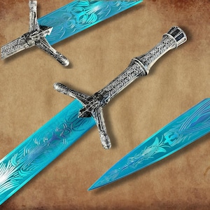 Könnte beinhalten: Aufwendige Fantasy-Schwerter mit silbernen Griffen und hellblauen Klingen. Die Klingen weisen aufwendige geätzte Designs auf. Die Schwerter werden vor einem braunen Hintergrund präsentiert.