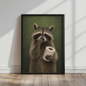 以下が含まれることがあります： 暗い緑色の背景にアライグマのリアルなイラストが描かれた額装されたウォールアートプリント。アライグマは灰色と黒の毛並みで、目の周りに黒いマスクがあり、片方の前足で白いトイレットペーパーのロールを持っています。
