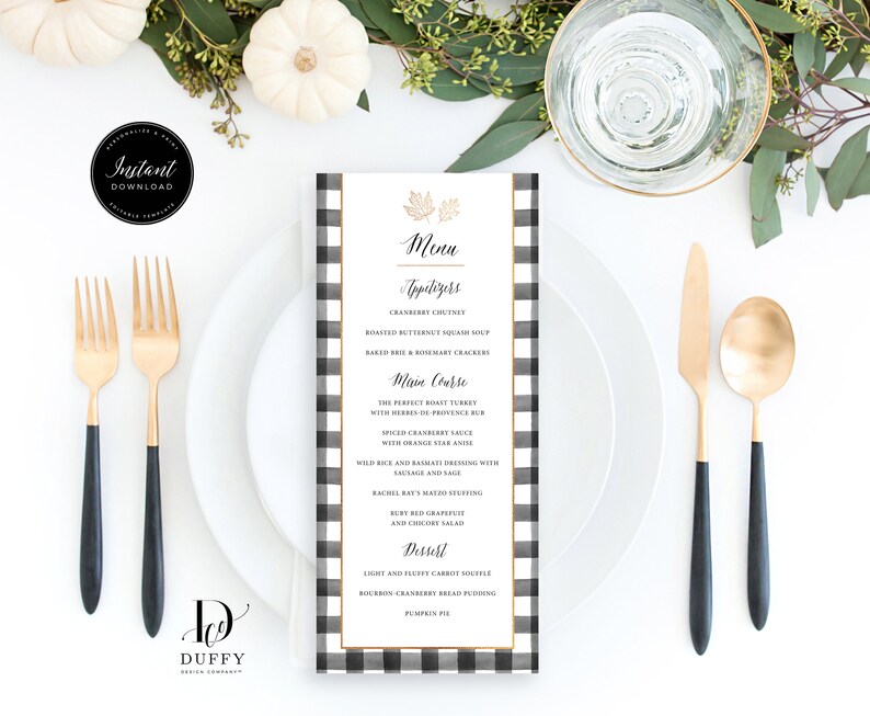 May include: A black and white checkered menu card with gold accents. The menu card features a Thanksgiving-themed menu with appetizers, main course, and dessert options. The text on the menu card reads: "Menu", "Appetizers", "Cranberry Chutney", "Roasted Butternut Squash Soup", "Baked Brie & Rosemary Crackers", "Main Course", "The Perfect Roast Turkey", "With Herbs de Provence Rub", "Spiced Cranberry Sauce", "With Orange Star Anise", "Wild Rice and Balsamic Dressing with Sausage and Sage", "Rachel Ray's Mayo Stuffing", "But Red Grapefruit", "And Cranberry Salad", "Dessert", "Light and Fluffy Carrot Souffle", "Bourbon Cranberry Bread Pudding", "Pumpkin Pie".