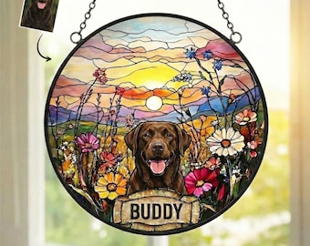 May include: Round stained glass window featuring a brown Labrador Retriever in a field of colorful flowers. The sunset scene includes a banner that reads "Buddy". A smaller image of the dog is in the upper left corner. The window hangs from a chain.