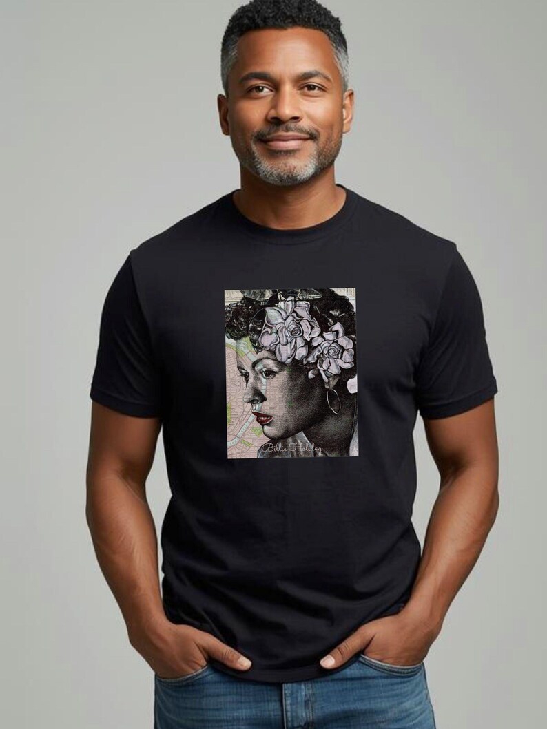 May include: Black t-shirt featuring a portrait of a woman with flowers in her hair. The portrait is in black and white with a map background. The t-shirt is worn by a person with gray hair and a beard.
