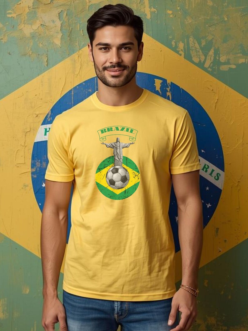 May include: Yellow t-shirt featuring a graphic of Christ the Redeemer statue, a soccer ball, and the word "BRAZIL" on a banner. The design is set against a Brazilian flag background. The shirt is short-sleeved.