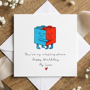 Cartão de aniversário estilo Lego com casal se abraçando, bilhete de amor com peça faltando, personagens fofos em blocos, cartão romântico para parceiro(a), lembrança de aniversário.