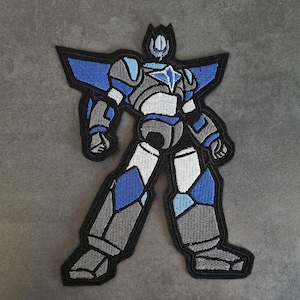 Könnte beinhalten: Gestickter Aufnäher mit einem stilisierten Roboter in Blau-, Grau- und Weißtönen, umrandet von Schwarz. Der Roboter hat ein geometrisches Design mit eckigen Formen und einem detaillierten Aussehen, geeignet für Kleidung oder Accessoires.