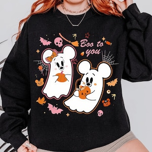 May include: Black sweatshirt with a Halloween graphic. The design includes two cartoon ghost characters holding pumpkins, with the phrase "Boo to you" and Halloween icons such as bats, spiders, and skulls.